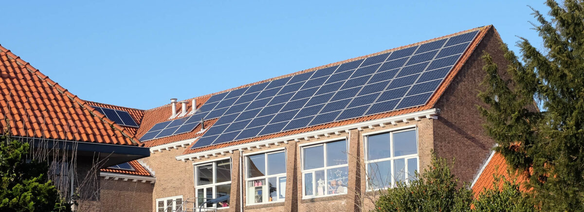 Zonnepanelen op het schuine dak van een schoolgebouw