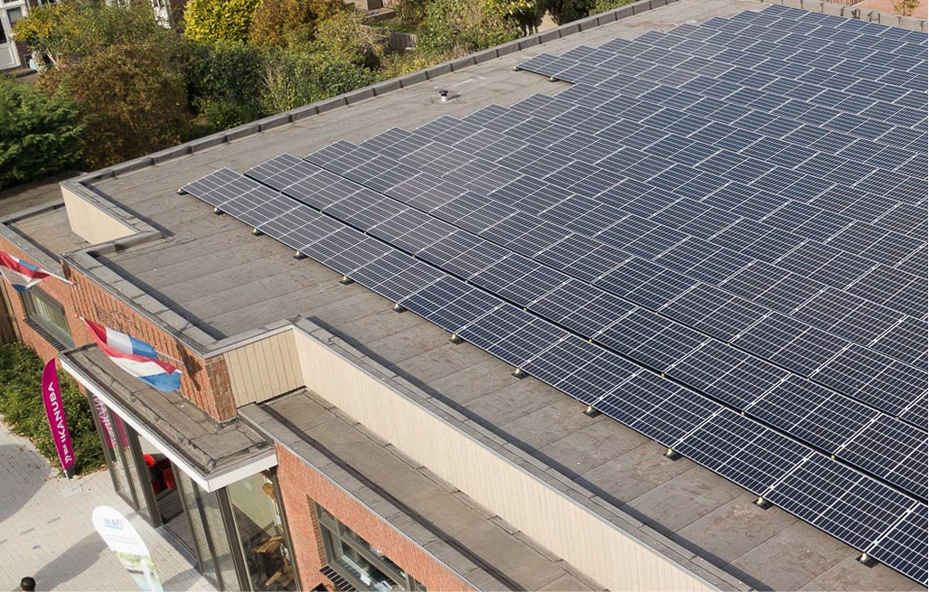 Zonnepanelen op het grote platte dak van een winkelpand
